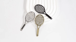 Detailed view of tennis racket charms in silver, black, and bronze for DIY crafts