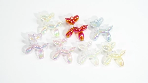 Macro detail of 7 iridescent bubble balloon dog charms with pearl collars and hooks