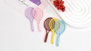 Close-up of five colorful mini plastic tennis racket charms for DIY jewelry and crafts