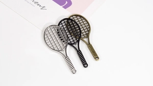 Detail showing metal tennis racket pendants in silver, black and antique bronze finishes