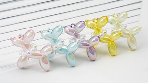 Detailed view of bubble dog pendants in five iridescent pastel colors with pearl collars