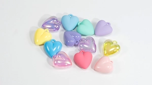 Close-up of colorful heart charms in pastel resin and glitter finishes for DIY crafts