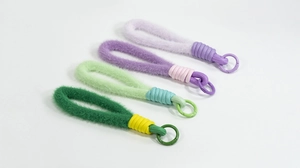 Details van vier kleurrijke pluche polsband-sleutelhangers met gevlochten koord