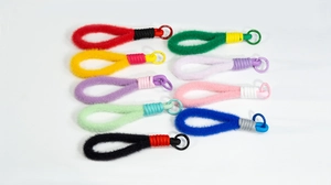 Close-up van negen kleurrijke handgemaakte pluche sleutelhangers met gevlochten touwen