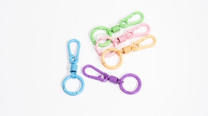 Macro detail of colorful macaron spring keychain hooks in pastel spray paint finish