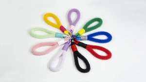 Platliggende weergave van kleurrijke handgemaakte pluche hangers in radiaal patroon