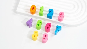 Makroaufnahme bunter Acryl-Zahlenperlen im Dopamin-Stil mit Löchern für DIY-Schmuck