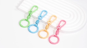 Set of four pastel macaron metal spring keychains in green, blue, orange, and pink colors