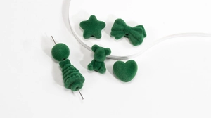 Détail de perles floquées vert foncé en forme de cœur et d'ours pour la création de bijoux DIY