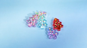 Détail macro de perles sapin de Noël en acrylique transparent avec pois colorés peints