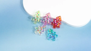 Vue macro de perles de sapin de Noël en acrylique coloré pour bijoux DIY et décoration