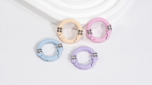 Dettaglio di anelli a molla color macaron con trama a scaglie e strass per creazioni DIY