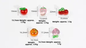 Detailed view of colorful glass fruit charms including apple, strawberry and persimmon