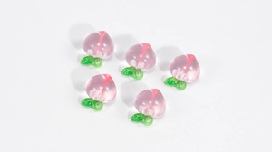 Detailed macro view of five translucent peach pendants with green leaf ring hook