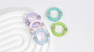 Dettaglio di moschettoni rotondi colorati in lega con strass per accessori fai-da-te