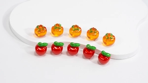 Macro detail of 10-piece DIY glass persimmon and apple pendants for jewelry making