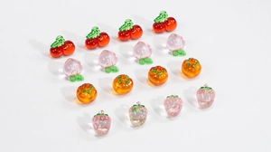 Macro detail of sixteen colorful transparent fruit-shaped DIY pendants and charms