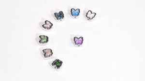 Detailed view of colorful butterfly-shaped DIY beads with metal edges and side holes