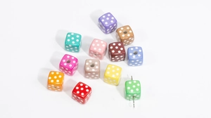 Detailed view of colorful acrylic cube beads with polka dots and visible threading holes