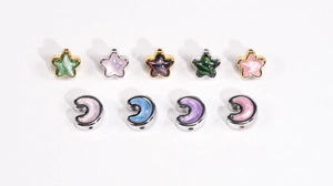 Macro view of star and moon charms with marbled texture and metallic borders for DIY jewelry