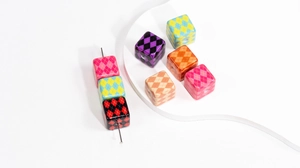 Macro detail of cube resin beads with colorful argyle patterns for DIY jewelry making