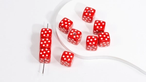 Macro detail of red acrylic cube beads with white polka dots for DIY jewelry making