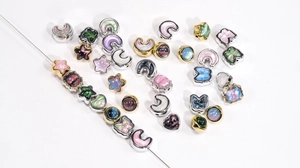 Macro detail of star moon and butterfly beads with colorful oil painting resin inlay