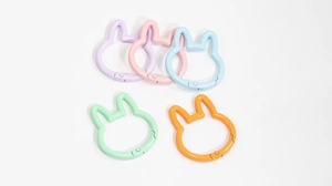 Macro detail of rabbit-shaped spring buckles in five vibrant pastel candy colors