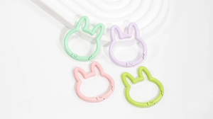 Close-up of four macaron-colored bunny-shaped spring ring buckles for DIY keychains