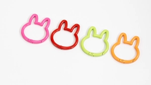 Detail of rabbit shaped metal spring ring carabiners in colorful glossy enamel finish