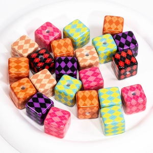 Colorful argyle pattern square beads in a white dish for DIY jewelry making and crafts