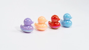 Dettaglio di perline a forma di papera iridescenti in viola arancio rosso e blu