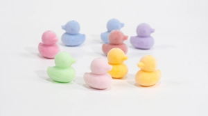 Dettaglio macro di perline a forma di papera colorate con fori per gioielli fai da te