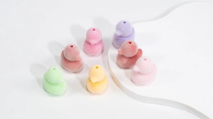 Dettaglio macro di perline colorate a forma di anatra floccata con fori per gioielli DIY