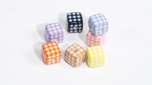 Macro view of colorful checkered acrylic cube beads with center holes for DIY crafts