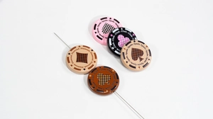 Macro detail of poker themed resin beads with spades and clubs patterns on a needle