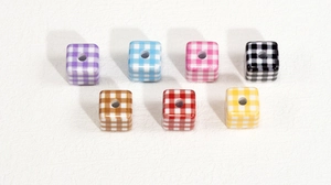 Macro view of colorful acrylic cube beads with checkered pattern for DIY crafts