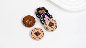 Detailed close-up of acrylic poker suit beads with spade and heart patterns for DIY