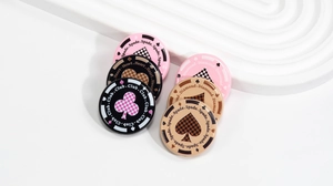 Detailed view of checkered poker-themed beads with spade and heart suit motifs