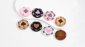Macro detail of poker suit acrylic beads showing thread holes and spade heart patterns