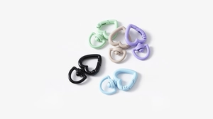 Macro detail of heart-shaped spring rings in matte colorful lacquer for DIY keychains