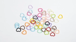Detailed view of colorful heart-shaped twist rings in various macaron colors for DIY jewelry