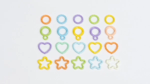 Macro detail of colorful twisted macaron resin rings, hearts and stars DIY jewelry parts