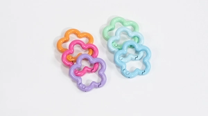 Flache Darstellung bunter Karabinerhaken in Blumenform in verschiedenen Pastellfarben