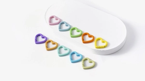 Vista macro de mosquetones metálicos coloridos en forma de corazón para accesorios DIY
