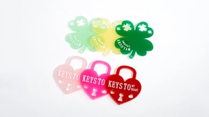 Macro detail of acrylic clover charms and heart locks with My Lucky Charms engravings
