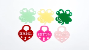 Detail of colorful acrylic lucky clover and heart lock pendants with engraved text