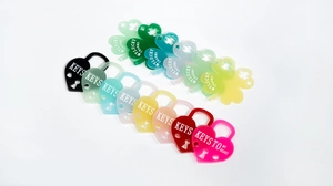 Macro detail of colorful acrylic heart lock and lucky clover charms with engraved text