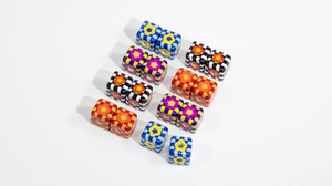 Macro detail of colorful checkered cube beads with floral patterns for DIY jewelry crafting