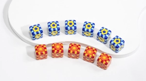 Macro detail of checkered cube beads with floral patterns for DIY jewelry making